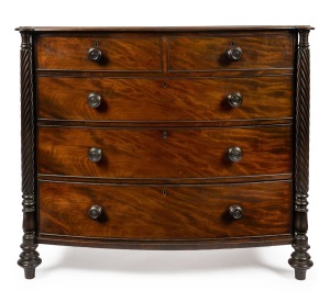 An antique English bow front mahogany chest of five drawers with cock-beading, full length quill turned columns with castle tops and turned bun feet, circa 1845, stamped "KERBY, 545 New Oxford Street", 102cm high, 119cm wide, 51cm deep.