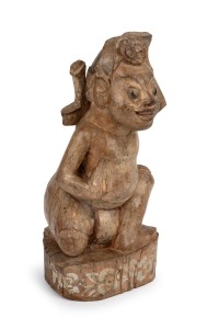 [DONALD FRIEND INTEREST] A vintage Balinese carved wooden and remains of polychrome finish sculpture of a kneeling man with kris, circa 1930s, 38cm high. PROVENANCE: Works From The Donald Friend Collection, Deutscher and Hackett, Sydney 2013, lot 49. Also featured in the book "DONALD FRIEND'S BALI" page 56. Catalogue and publication included in this lot, (3 items).