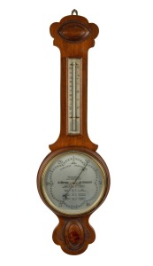 An antique English aneroid wheel barometer with mercury thermometer, the main dial with weather indications, housed in a walnut case, early 20th century, 81cm high.