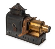 MAGIC LANTERN: Black-lacquered tin body, Voigtl&auml;nder brass rack-and-pinion lens, dual side-opening doors with blue glass peepholes, wooden slide holder in place, c. 1900s; dimensions 31 x 13 x 36cm.