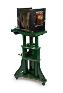 Circa 1920s large format studio camera, plate dimensions 21 x 16.5cm, Taylor Taylor & Hobson Cooke Series II 10 x 8" Eq. Focus brass lens, intact black bellows, on adjustable timber stand; height set to approx. 1.5m.