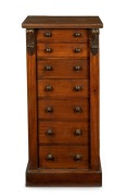 An antique English mahogany Wellington chest of seven graduated drawers with carved corbel decoration, bearing brass maker's plaque "W.H. TRAVERS, Endell St. & Castle St. Long Acre, W.C.", 19th century, 102cm high, 49cm wide, 36cm deep.