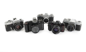 SLR CAMERAS: 1970s-90s group comprising Konica Autoreflex T3, Konica DX, Mamiya/Sekor 500 DTL, Yashica TL (body only), and Yoshita MF-A7000F. (5 items)