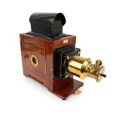 Large c. 1890s mahogany and brass MAGIC LANTERN with rack-and-pinion lens, tin chimney element, side-opening door with red glass peephole, "W. Watson & Sons 251 Swanston St Melbourne" retailer's plate; later retrofitted for electricity, dimensions approx.