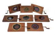 CHROMATROPES: Group of eight different designs, mid-19th century, brass cranks, timber frames.