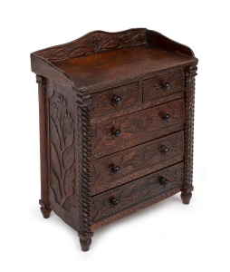 An unusual folk art miniature five drawer chest, crafted from cigar box cedar, attractively carved with floral decoration, late 19th century, 32cm high, 26cm wide, 15.5cm deep.