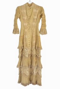 An antique dress, pleated silk and fine cotton with mother of pearl buttons, 19th/20th century.