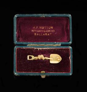 GOLD MINING BROOCH: The single shovel with applied nugget and rope. 18ct yellow gold. Weight &nbsp;4.56 grams. Original fitted box by H.F.Hutton of Ballarat. The Hutton firm was Ballarats finest Jewellers in the 19th century with an impressive showroom on Stur