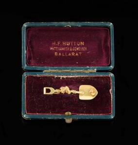 GOLD MINING BROOCH: The single shovel with applied nugget and rope. 18ct yellow gold. Weight  4.56 grams. Original fitted box by H.F.Hutton of Ballarat. The Hutton firm was Ballarats finest Jewellers in the 19th century with an impressive showroom on Stur