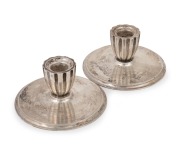GEORG JENSEN pair of Danish sterling silver candle holders, designed by Harald Nielsen (1892-1977), mid 20th century, ​​​​​​​3cm high, 6.5cm diameter, 76 grams total.
