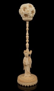 A Chinese carved ivory puzzle ball on figural stand, early to mid 20th century, 22cm high overall.