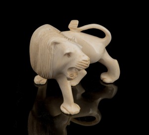 An Indian carved ivory lion ornament, early to mid 20th century, ​​​​​​​9cm high, 11cm wide.