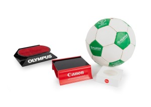 Group of branded items comprising three retail camera display stands (Canon/Leica/Olympus) and a Fujifilm soccer ball (produced for the 2002 FIFA World Cup; height 21cm). (4 items)