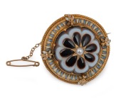 A fine quality antique 15ct yellow gold circular brooch adorned with an impressive carved banded agate, set with central pearl and finished in blue and white enamel around the border, mid 19th century, ​​​​​​​5cm diameter, 15.9 grams total.