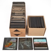 A collection of 83 x 83mm photographic glass slides for magic lantern, many hand-tinted, including many World War I views (British Whippet tank charge, burning of piles of German war dead, King George V touring ordnance factory). (100+ items)