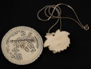 A carved ivory floral pendant on a white metal chain; together with a carved ivory monkey brooch, 19th/20th century, (2 items), the brooch 5cm diameter. - 2