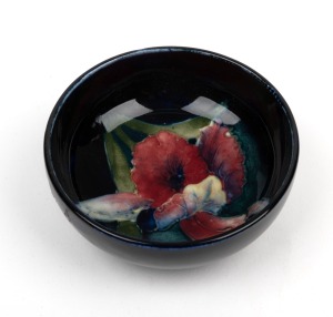 MOORCROFT "Iris" English pottery salt cellar, impressed "Moorcroft, Made In England" with original paper labels, 3cm high, 7.5cm diameter.