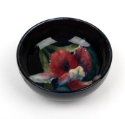 MOORCROFT "Iris" English pottery salt cellar, impressed "Moorcroft, Made In England" with original paper labels, 3cm high, 7.5cm diameter.