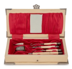 A vintage celluloid fold-out sewing kit, lined in red satin with assorted sewing implements, early to mid 20th century, 17cm wide.