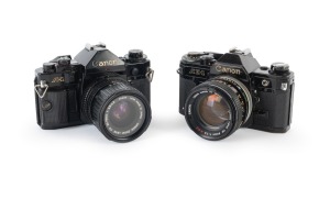 CANON: Pair of 1970s black-body SLRs, comprising Canon A-1 (Zoom FD 35-70mm f3.5-4.5) and Canon AE-1 (FD SSC 50mm f1.4).