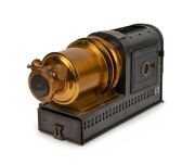 NEGRETTI & ZAMBRA: Circa 1900s magic lantern, black-lacquered tin body, dual side-opening doors with blue glass peepholes; dimensions 22 x 13.5 x 40cm.