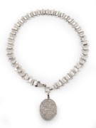 An antique engraved sterling silver locket and chain, 19th century, the locket 5cm high overall including bow, the chain 40cm long overall, 37 grams total.