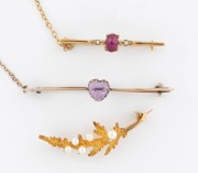 An antique 9ct gold bar brooch with cabochon ruby flanked by seed pearls; together with an antique 9ct rose gold bar brooch with heart shaped amethyst and a vintage 9ct gold fern leaf pearl brooch, early to mid 20th century, (3 items), the largest 5cm wid