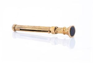 An antique 9ct gold retractable toothpick with gold stone seal top, 6.5cm high when open, 2 grams total.