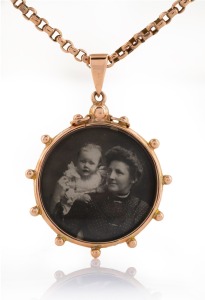 An antique 9ct rose gold double sided photo pendant on chain, stamped "9ct, W.V.", 19th/20th century, the chain 50cm long, 10.3 grams, 15.4 grams total including glass, the pendant 5cm high overall including bow.