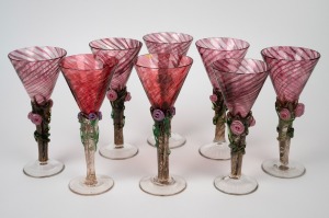 COLIN HEANEY set of eight Australian art glass champagne flutes with applied floral decoration and ruby glass bowls, engraved "Heaney, '89", 20cm high.