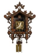 An antique German Black Forest railway cuckoo wall clock in carved and fretted linden wood case with Tunbridge style parquetry banding, later fitted transparent dial plate displaying the fretted brass plate 30 hour movement, cuckoo and bellows, circa 1900