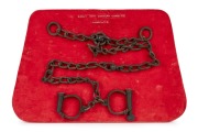 HIATT antique handcuffs and key with attached chain, mounted on red velvet display board, 19th century.