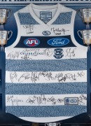 GEELONG CATS PREMIERSHIP HISTORY GUERNSEY - 2011 A superbly presented "150th Anniversary Guernsey" celebrating Geelong's nine premierships between 1925 and 2011; the original signatures of the 2009 Premiership team have been applied to the guernsey, which - 2