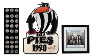 COLLINGWOOD: A collection of twenty-seven button badges (condition issues) nailed on to a display board; players include Peter Daicos, Tony Shaw, and Leigh Matthews; together with a signed timber Magpies mascot display (height 87cm), and one other. (3 items)