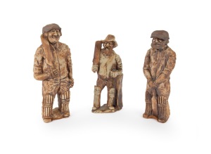 Three different ceramic clay figurines of cricketers holding bats; the tallest 23cm.