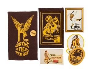 HAWTHORN FOOTBALL CLUB: A 1960s duffle-coat patch, a team tin badge, two different AMPOL stickers/decals, a 1970s Herald decal, and 1975 and 1976 Hawthorn Cheer Squad patches. (7 items).