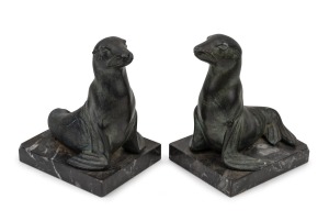 A pair of French Art Deco patinated spelter seal bookends on marble bases, signed "M. FONT", circa 1925, 13cm high.
