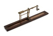 A. WILKINSON antique brass and timber sovereign scales with original lithograph paper instructions, 19th century, the case 15cm long when closed.