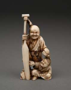 A Japanese carved marine ivory okimono figural group of a fisherman and child holding a paddle, Meiji period, 19th/20th century, ​​​​​​​8.5cm high.
