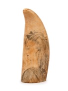 A scrimshaw whale's tooth with profile portrait of a lady, ​​​​​​​12.5cm high.