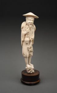 A Chinese carved ivory statue of an old fisherman, mounted on a turned timber plinth, 19th/20th century, 25cm high overall.