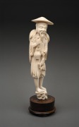 A Chinese carved ivory statue of an old fisherman, mounted on a turned timber plinth, 19th/20th century, ​​​​​​​25cm high overall.