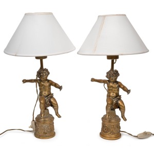 A pair of figural cast bronze table lamps, early 20th century, ​​​​​​​45cm high including the shades.
