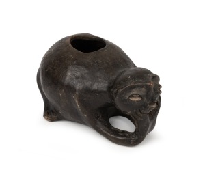 An antique pottery Moche jug with kneeling figure decoration and black painted finish, Peruvian origin, 9cm high, 17cm long.