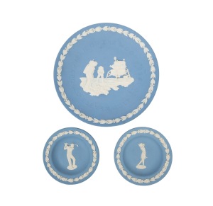 WEDGWOOD: A group of late-20th century jasperware ceramics, all impressed "WEDGWOOD", comprising a ring dish with male golfer, a ring dish with female golfer, and an Apollo 11 commemorative plate; the largest diameter 20cm. (3 items)