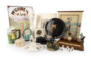 A diverse accumulation of golf-themed items, including a cast-iron mechanical money box, a "The Development of the Ball" wooden display, two clocks, a set of coasters, and more, plus three plain vases. (qty.)