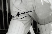 DON BRADMAN: Framed and glazed photograph print of Bradman stepping out to bat at the MCG, featuring Bradman's original signature in permanent marker; 60 x 50cm overall. - 2
