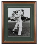DON BRADMAN: Framed and glazed photograph of Bradman posed with bat, featuring Bradman's original signature in permanent marker; 60 x 50cm overall.