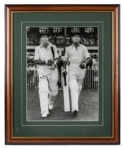 DON BRADMAN: Framed and glazed photograph of Bradman stepping out to bat alongside Jack Fingleton, featuring Bradman's original signature in permanent marker; 60 x 50cm overall.