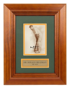 DON BRADMAN: Original signature in permanent marker on photograph print of Bradman at bat; framed and glazed, 43 x 33cm overall.